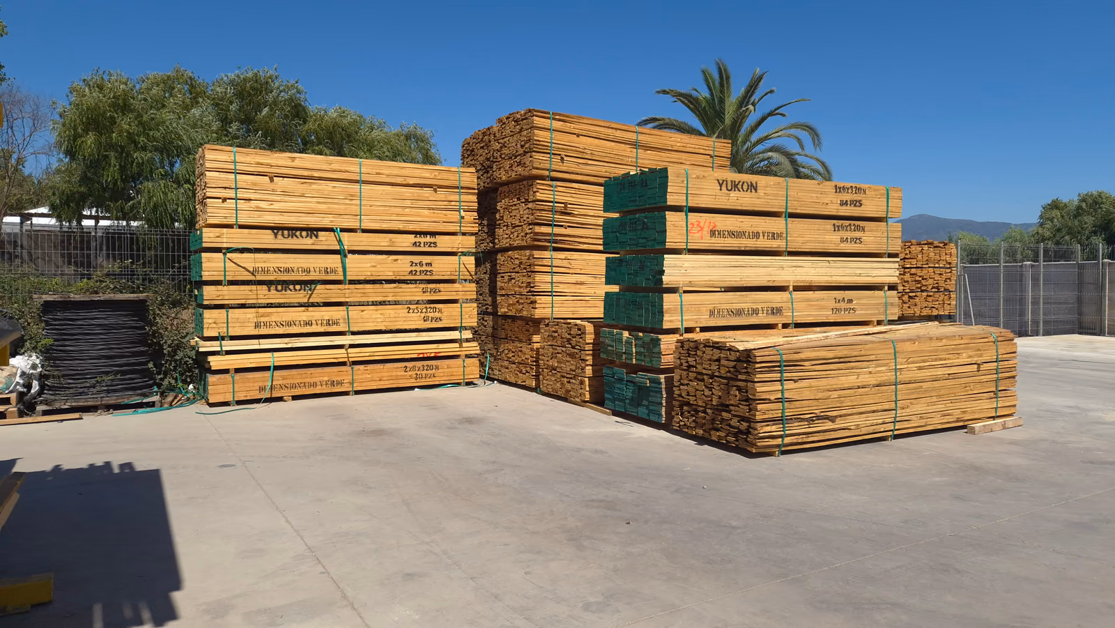 Pilas de madera aserrada en el patio